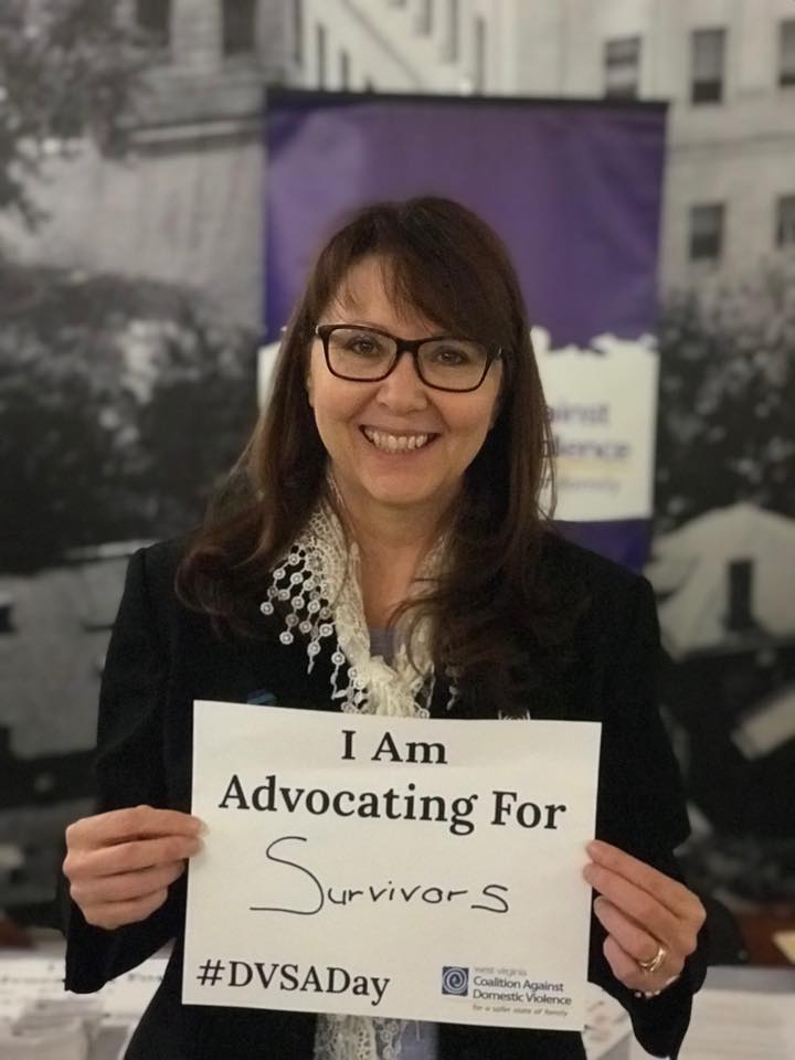A person holding a sign that says I am advocating for survivors