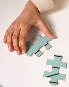 A hand trying to fit two puzzle pieces together