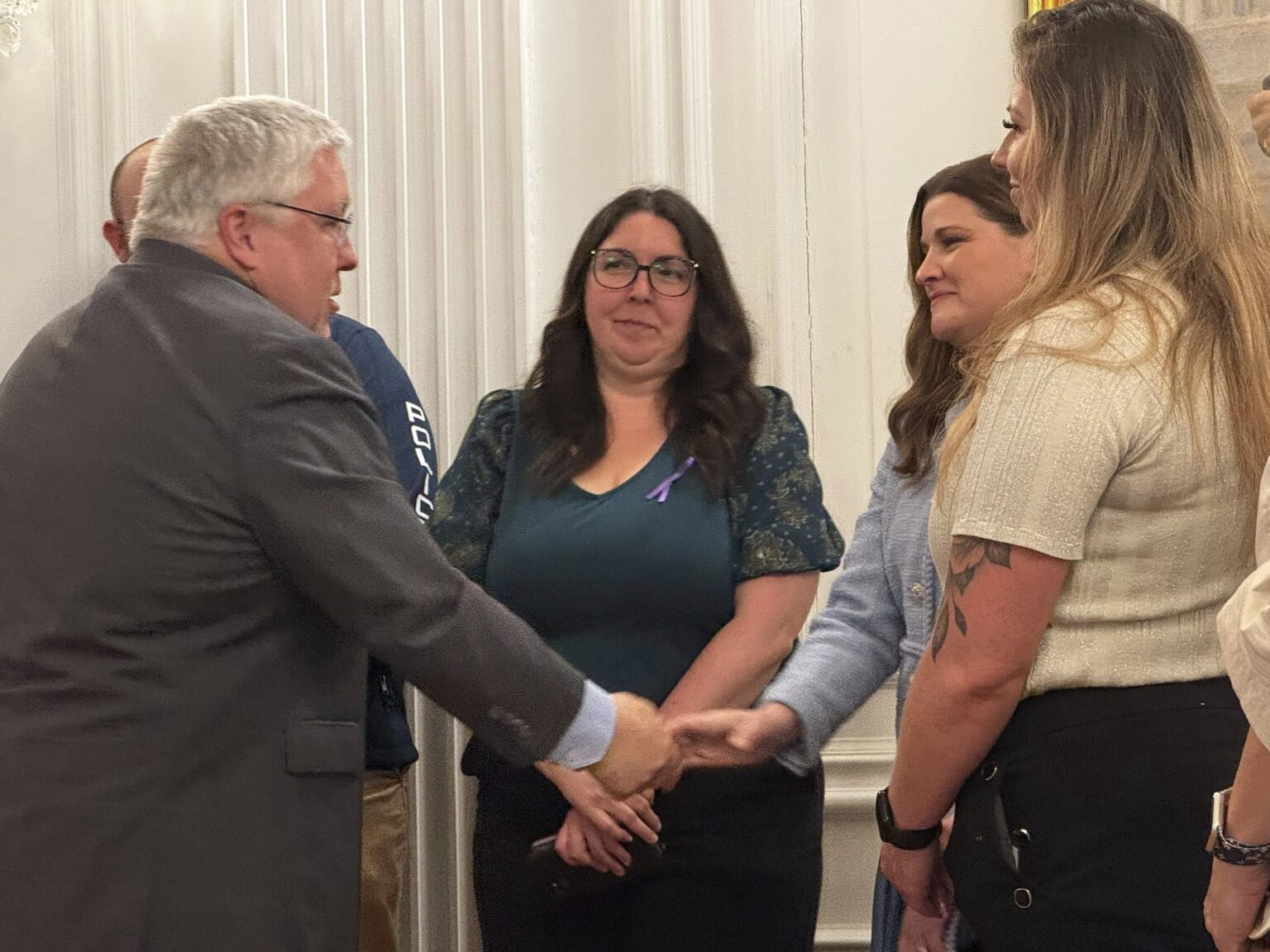 Governor Morrissey shakes hands with a Brittney Leavitt, two other stand by