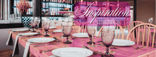 An image of a table with elegant place settings, including cut crystal glasses. A text overlay reads "Inspiration Luncheon"